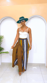 Model wearing a vibrant, multi-colored African Ankara pants and skirt with intricate patterns, featuring an elastic waistband and zipper closure.