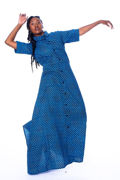 Photo of a woman wearing myObioma's maxi and button-down dress Blue Agege. The soft and comfortable fabric features gorgeous blue patterns scaled to feel like a lavish texture. The collared dress also includes medium-length sleeves for a fancy flair.
