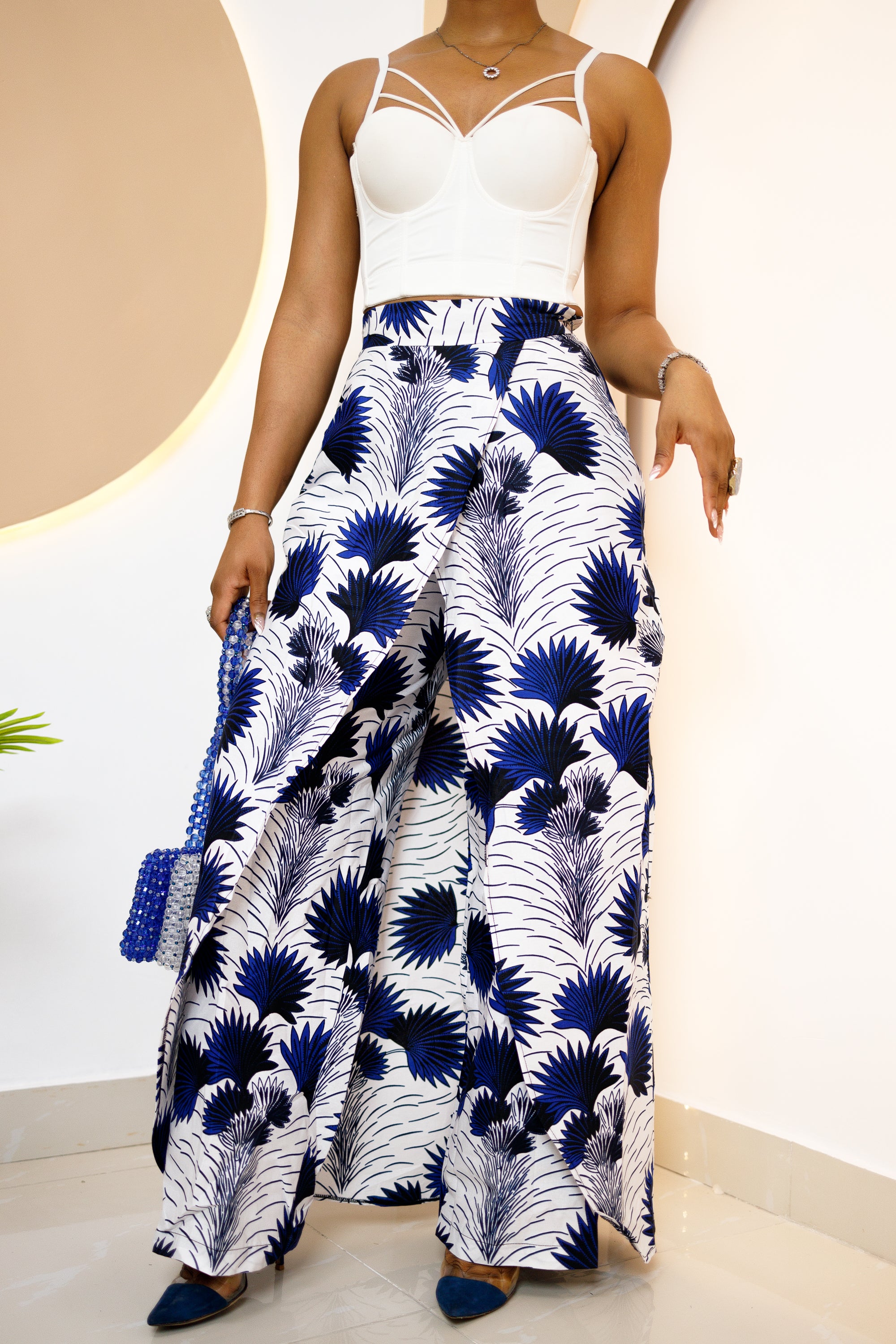 Model wearing a vibrant, multi-colored African Ankara pants and skirt with intricate patterns, featuring an elastic waistband and zipper closure.