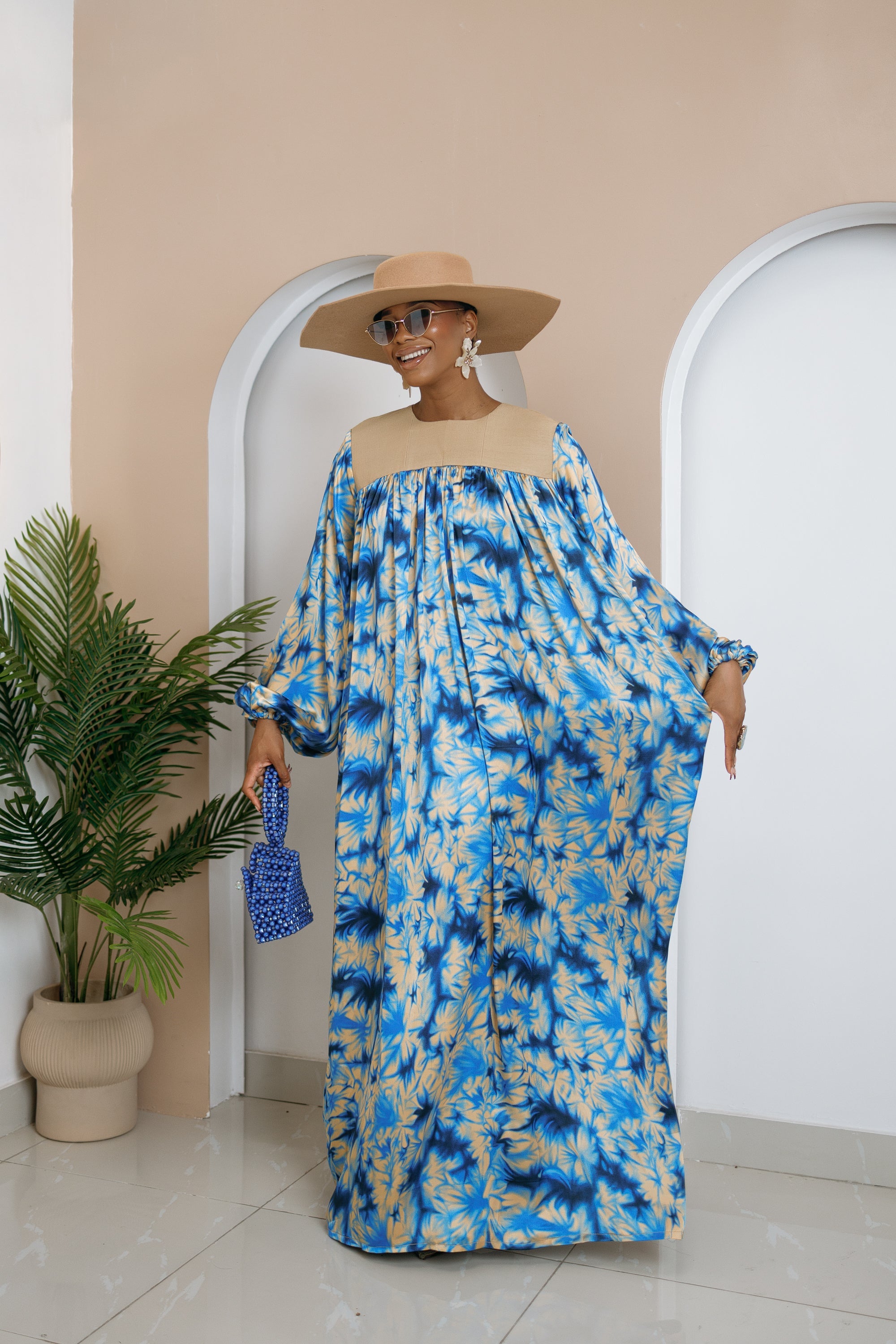 Model wearing Chikosolu floor-length silk and Aso Oke dress with yoke design, flowy sleeves, and side pockets.