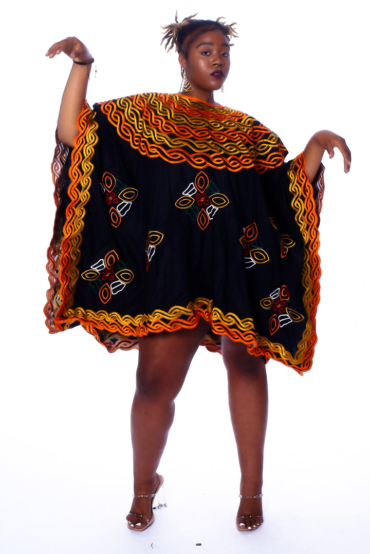 Photo of a woman wearing myObioma's Abebe Shirt Dress, which has scattered and multicolored flower-like embroidery. It includes a round neck design that loosens the silhouette.