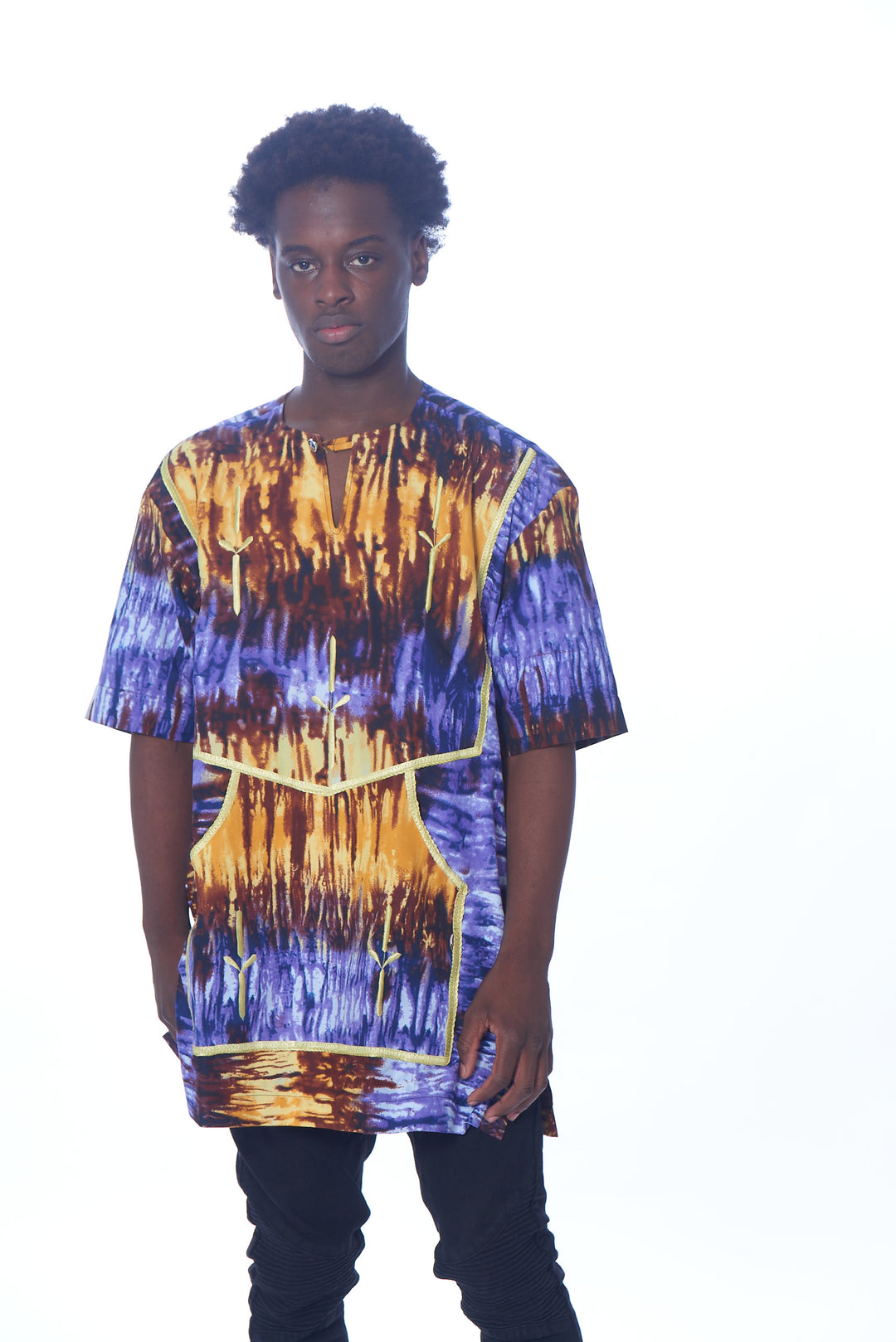 Photo of a man wearing myObioma's purple and orange Tye Dye Trad Kaftan. The loose-fitting shirt includes large kangaroo pockets with a yellow outline that are not only considerate for usage but blend with the colors of the shirt.