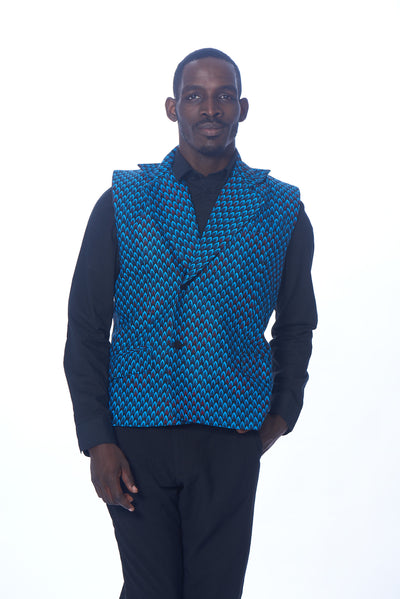 Photo of a man wearing myObioma's sleeveless and collared Nonso vest, which fits loosely. It includes a black button-front feature and a gorgeous blue and black pattern print throughout the material.