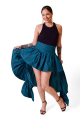 Model wearing Nkukwaya high-low tiered Ankara skirt in teal and black, styled with black top and boots, hand-crafted in Africa