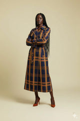 Woman wearing a long, patterned coat against a beige background