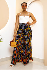 Model wearing a vibrant, multi-colored African Ankara pants and skirt with intricate patterns, featuring an elastic waistband and zipper closure.
