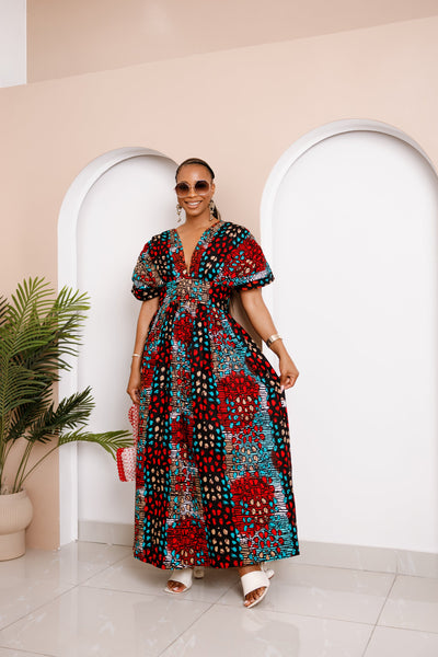 Model wearing Obidia Ankara Maxi Dress with puff sleeves and geometric red, teal, and black patterns