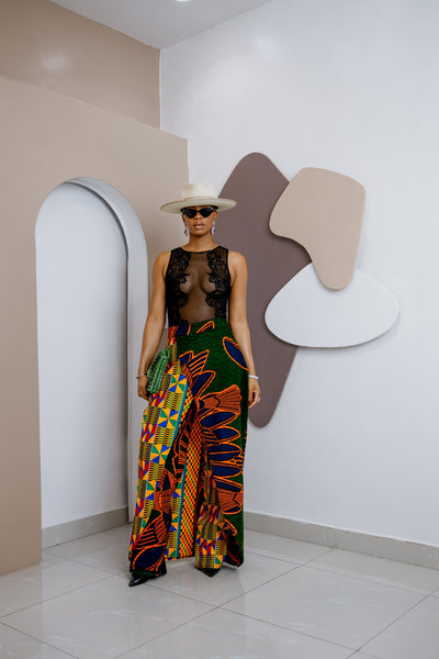 Model wearing a vibrant, multi-colored African Ankara pants and skirt with intricate patterns, featuring an elastic waistband and zipper closure.