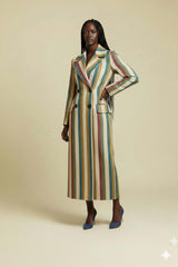 Woman wearing a long, multicolored striped coat on a beige background
