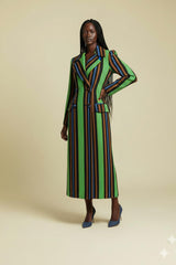 Woman wearing a long, multicolored striped coat on a beige background