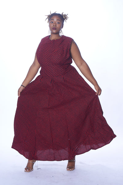 Photo of a woman wearing myObioma's sleeveless and maxi dress Red Abike. The soft and comfortable fabric features gorgeous red patterns scaled to feel like a lavish texture. The long dress also includes medium-length sleeves for a fancy flair.
