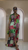 Model wearing Umuada Silk Ankara Kaftan – red, green, and yellow patchwork print maxi shirt dress with front slit.