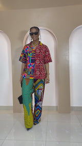 Model wearing Umunna unisex patchwork Ankara set featuring multi-colored cotton shirt and pants made from vibrant African print fabrics.