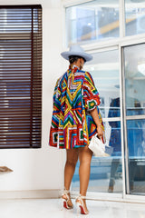 A woman posing in a multicolored African print mini dress.