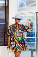 A woman posing in a multicolored African print mini dress.