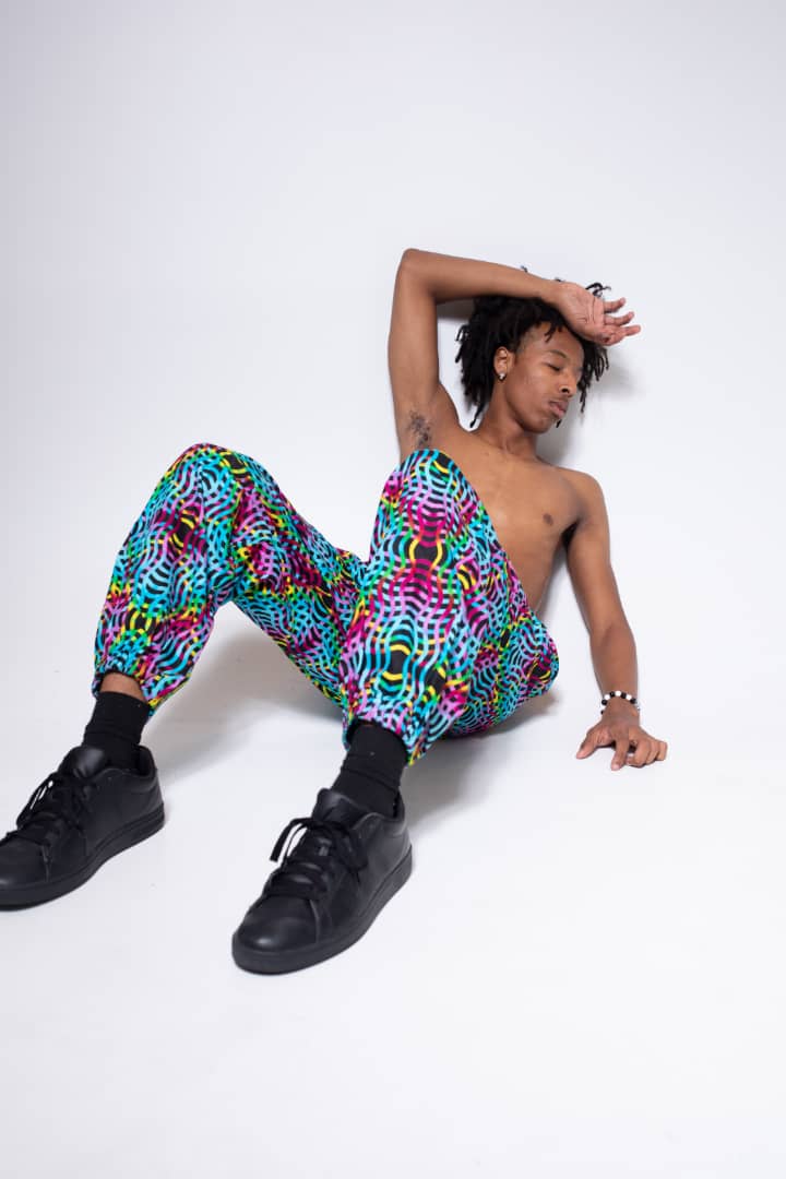 Blue, pink, purple, and yellow multicolored jogger pants with elastic waistband, cinched ankles, and slanted pockets.