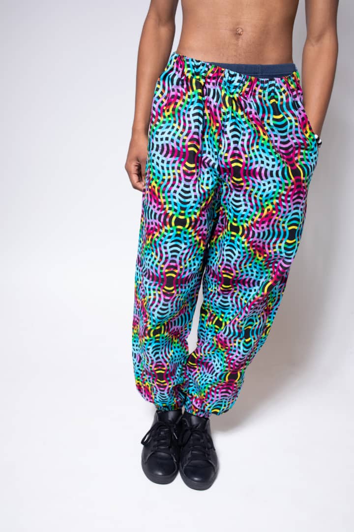 Blue, pink, purple, and yellow multicolored jogger pants with elastic waistband, cinched ankles, and slanted pockets.