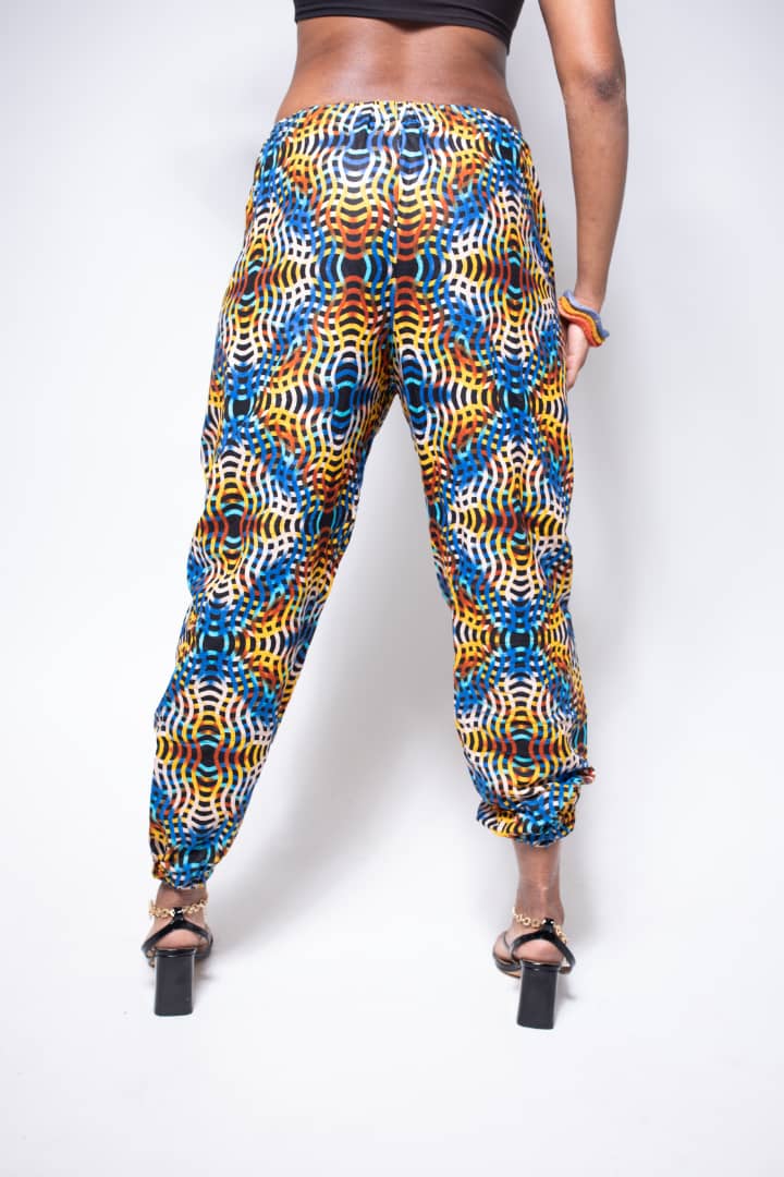 Blue, yellow, and orange multicolored jogger pants with elastic waistband, cinched ankles, and slanted pockets.