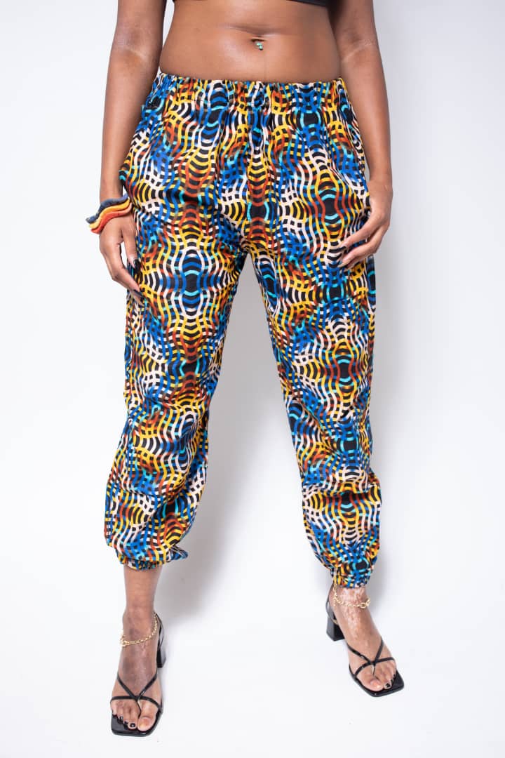 Blue, yellow, and orange multicolored jogger pants with elastic waistband, cinched ankles, and slanted pockets.