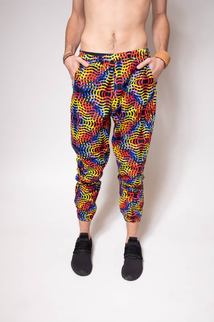Red, yellow, blue, and pink multicolored jogger pants with elastic waistband, cinched ankles, and slanted pockets.