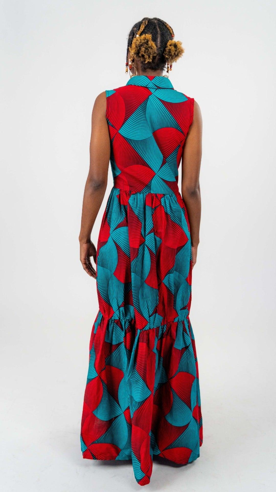 Red and blue patterned dress. Dress is sleeveless and collared, with a trumpet style silhouette and side leg slit.