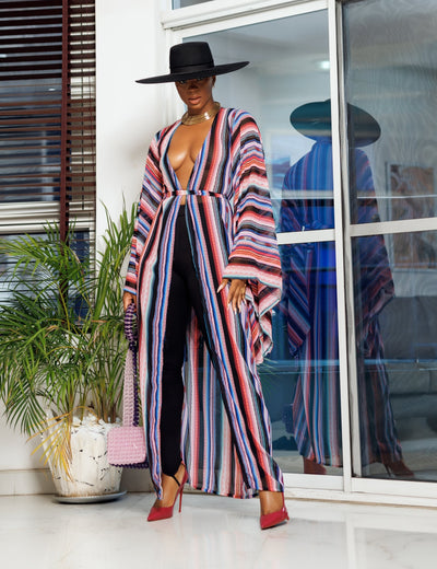 A woman posing in a multicolored chiffon fabric African kimono.