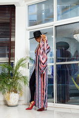 A woman posing in a multicolored chiffon fabric African kimono.