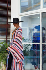 A woman posing in a multicolored chiffon fabric African kimono.