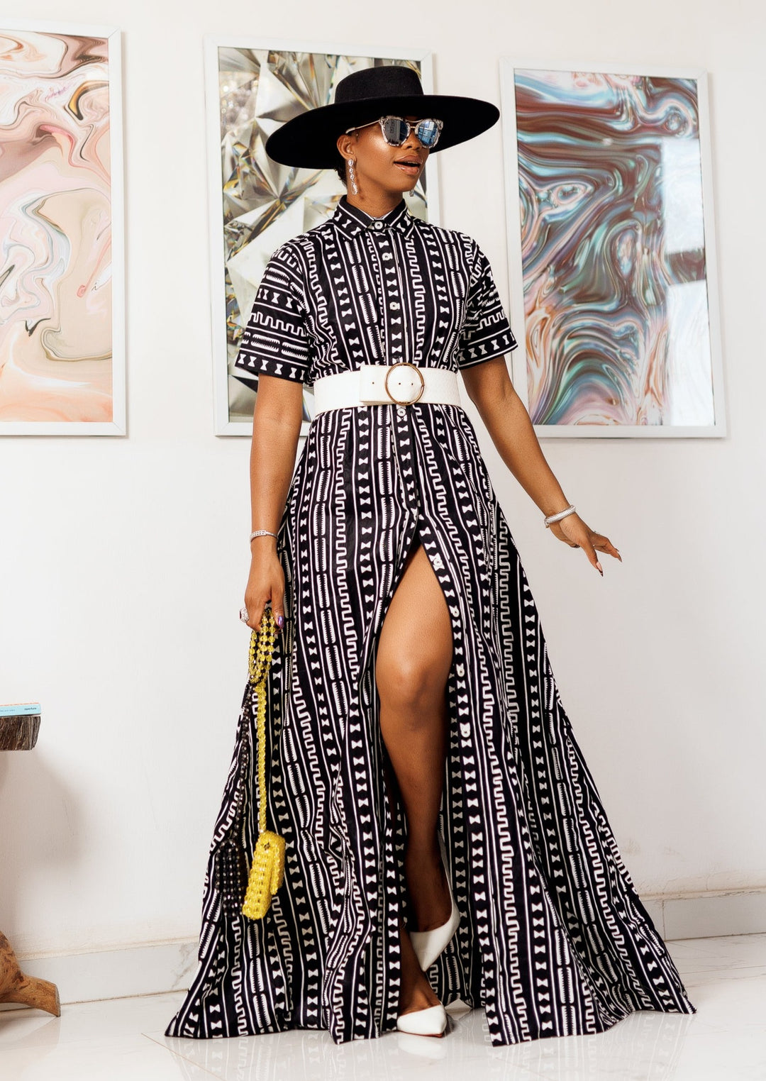 A woman posing in a black and white African print maxi kimono dress.
