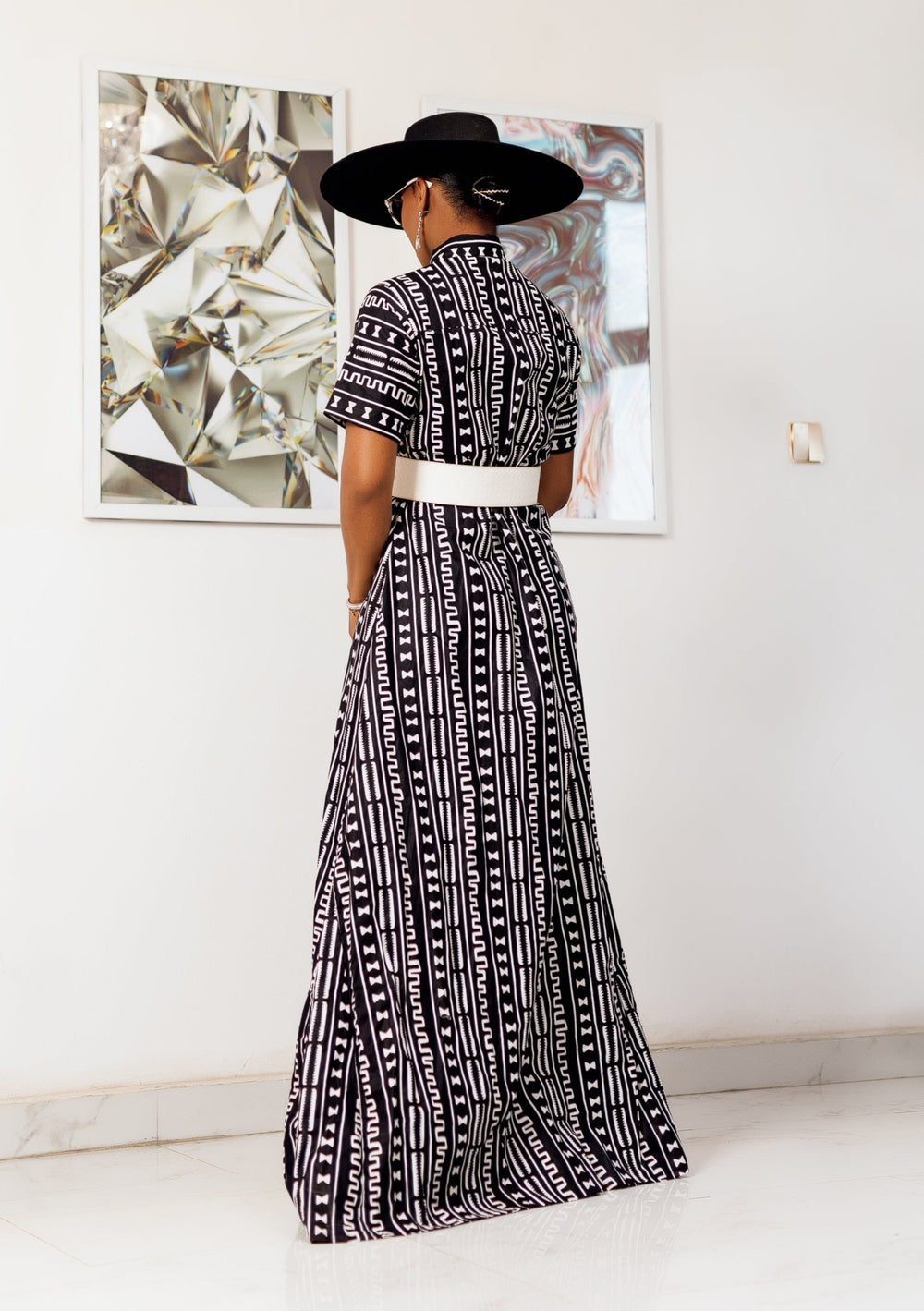 A woman posing in a black and white African print maxi kimono dress.