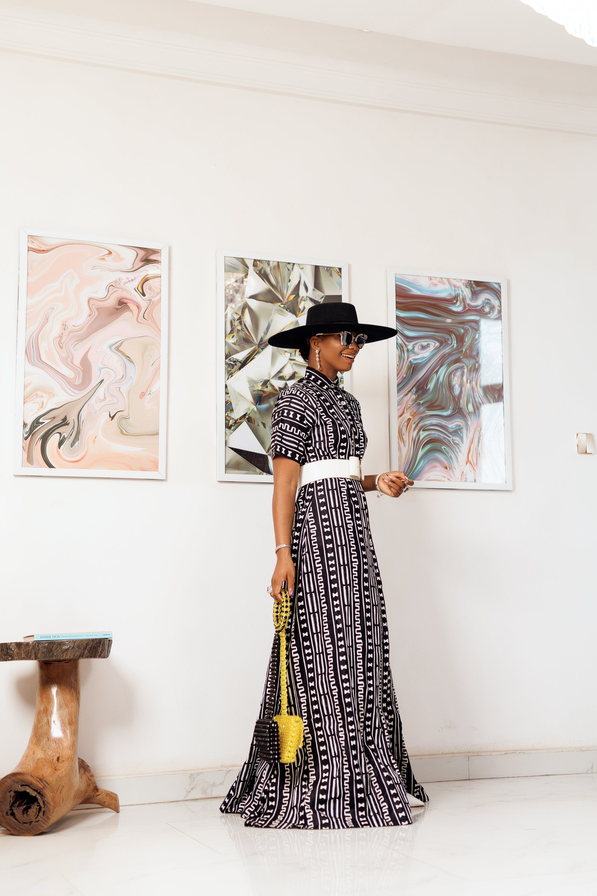 A woman posing in a black and white African print maxi kimono dress.