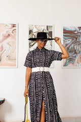 A woman posing in a black and white African print maxi kimono dress.