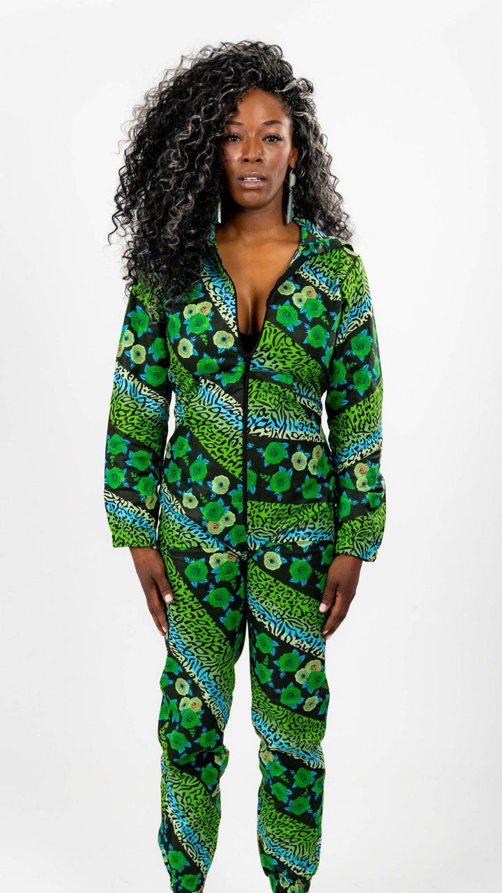 Green, blue, and black patterned full body onesie.  Onesie is long sleeved and hooded, with a black front zipper and elastic ankle bands.