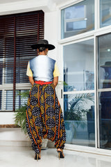 A woman posing in multicolored African Print parachute pants.