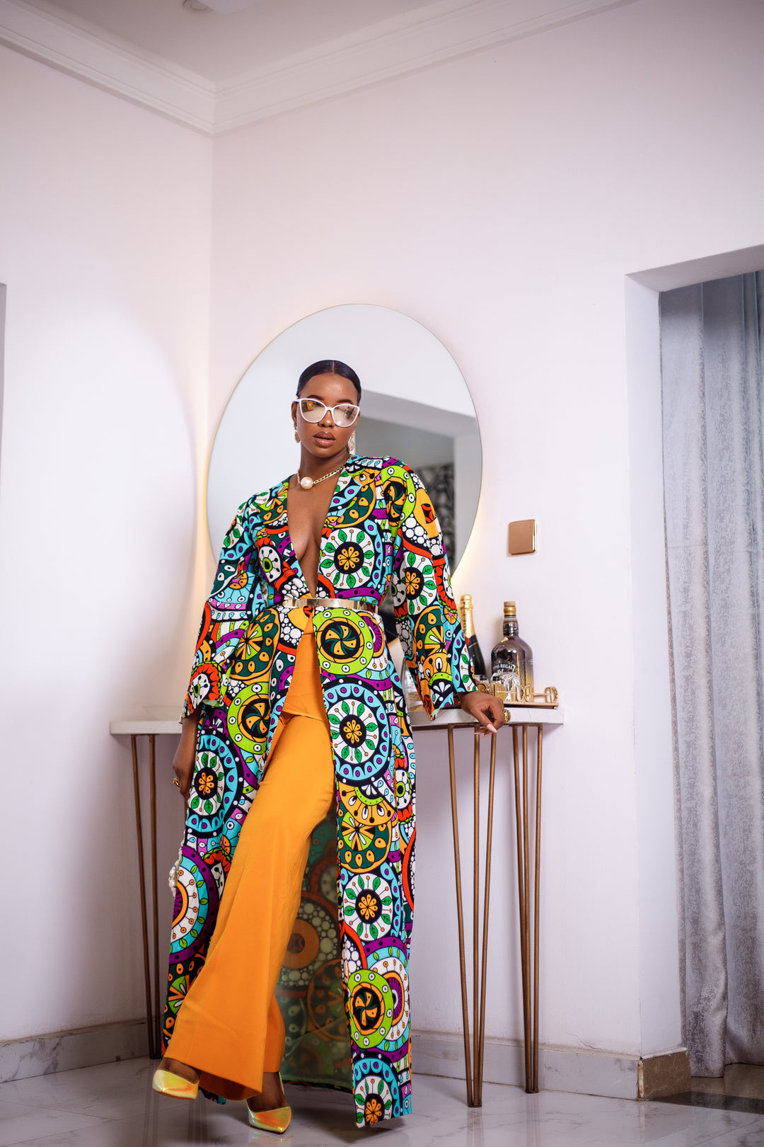 A woman posing in a multicolored African Print kimono.