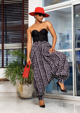 A woman posing in black and white African Print parachute pants.