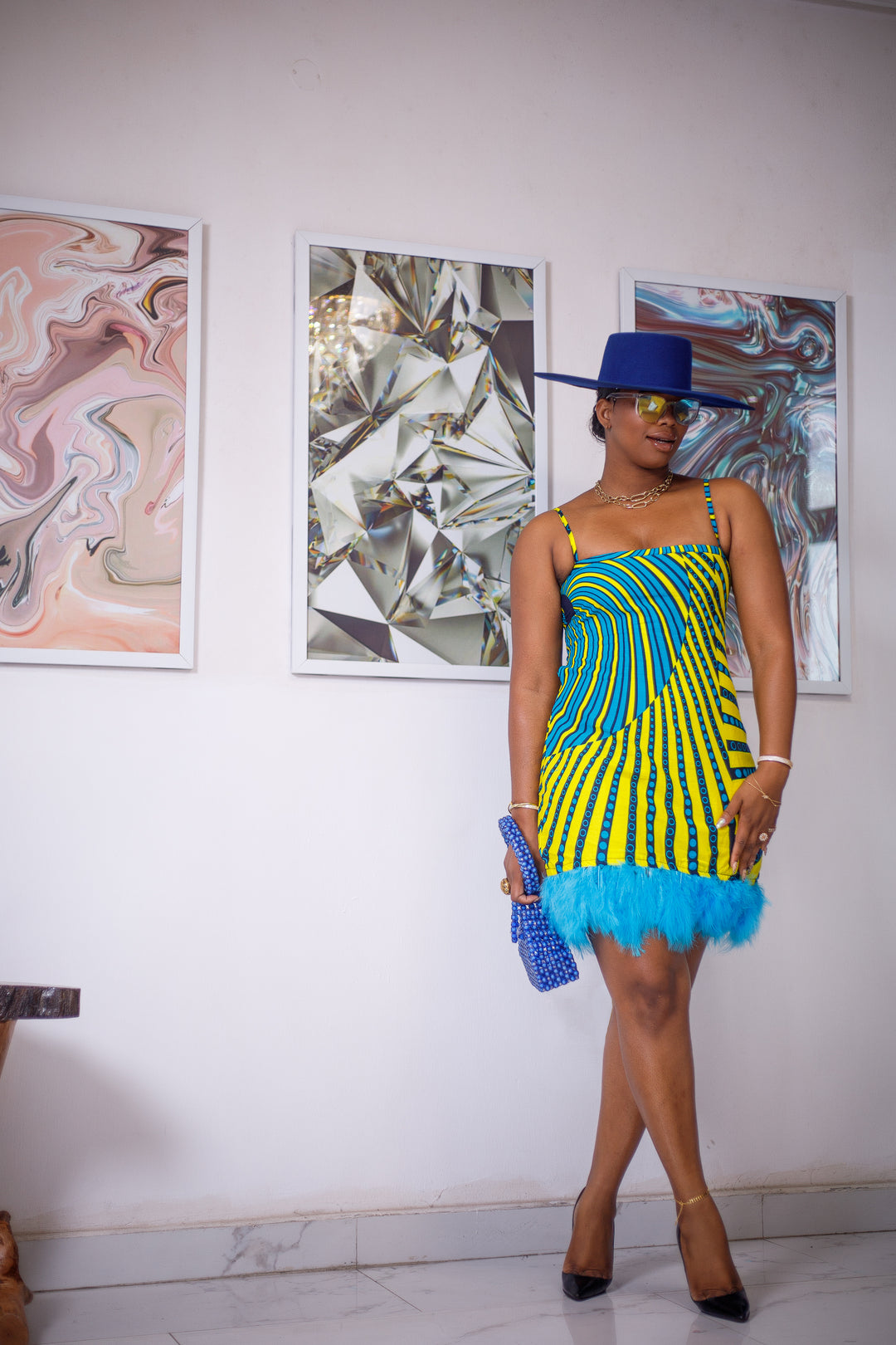 A woman posing in a blue and yellow African print mini dress.